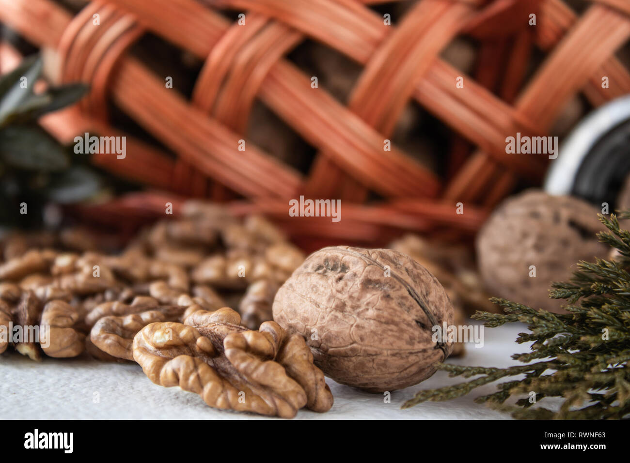 Noci e nocciole di dadi su uno sfondo bianco vicino al cestello. Foto Stock