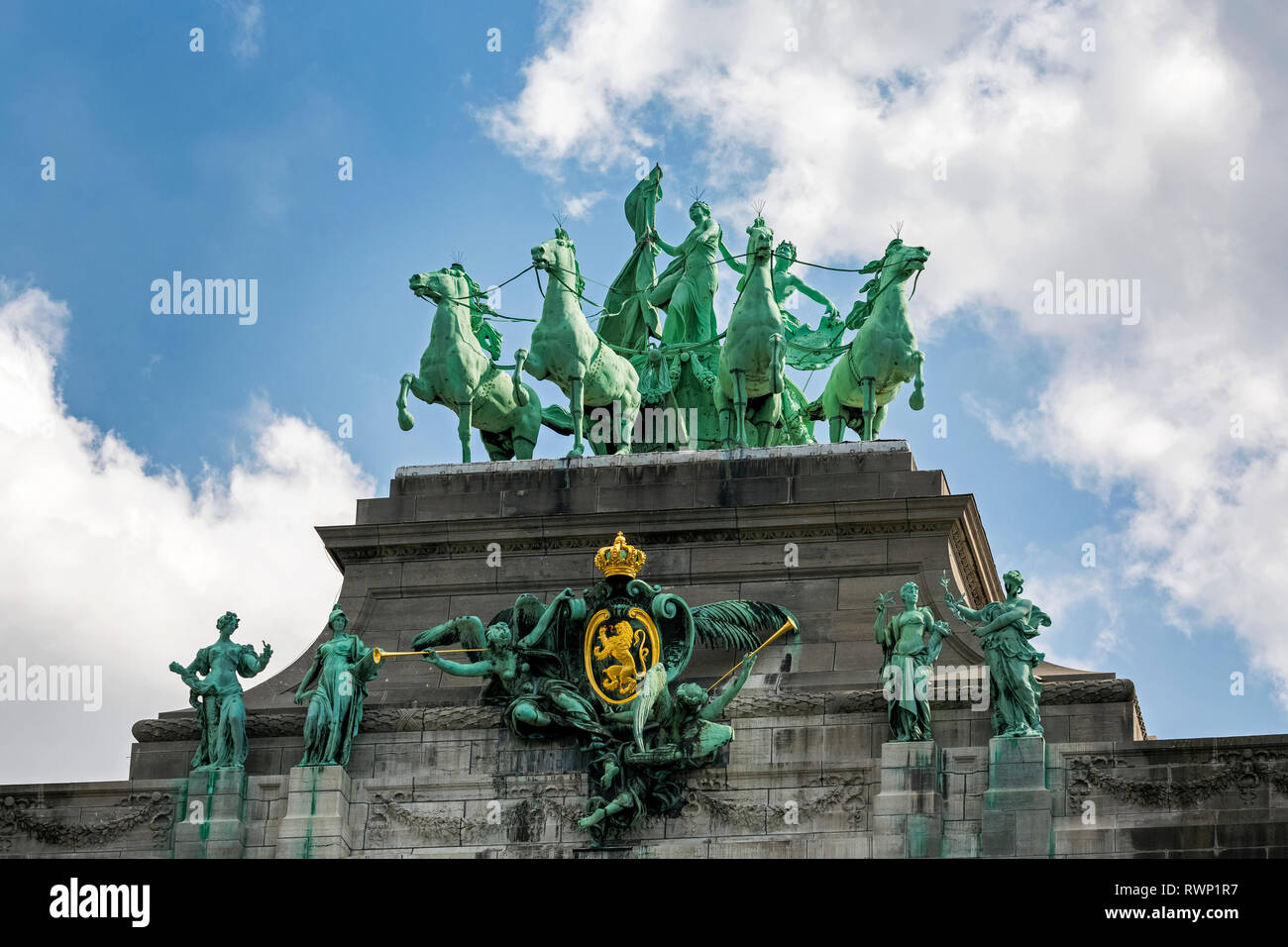 Statua di bronzo di carro e pilota con altre statue di bronzo sulla sommità del monement con cielo blu e nuvole; Bruxelles, Belgio Foto Stock