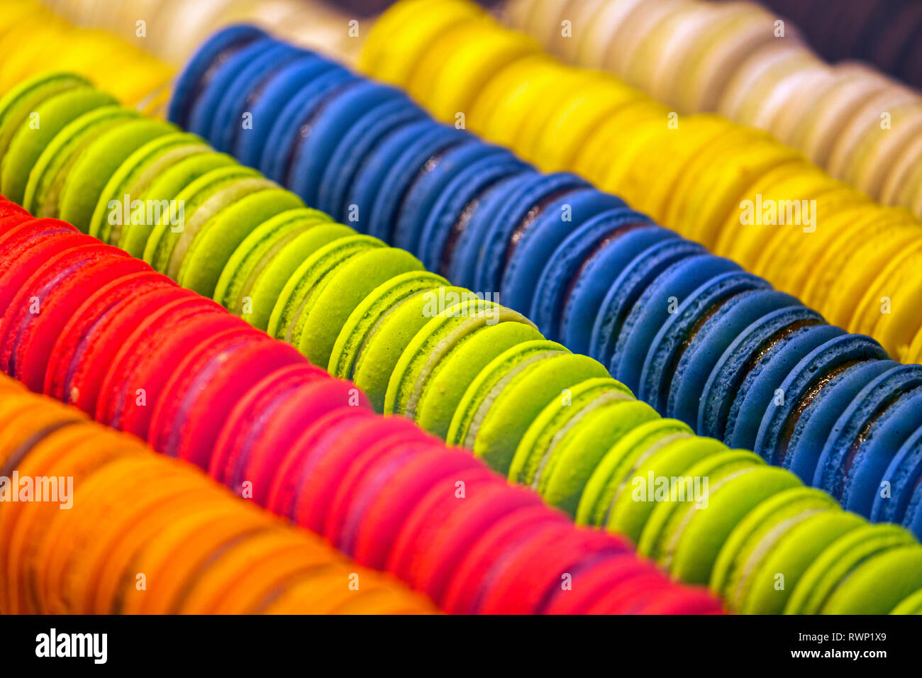 Close-up di amaretti colorati tutti in riga nella vetrina del negozio; città di Lussemburgo, Lussemburgo Foto Stock