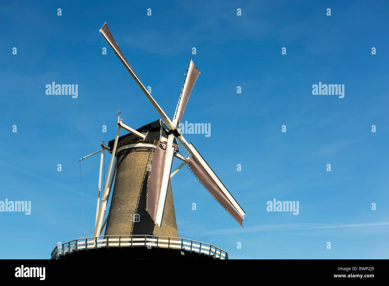 Guardando il vecchio mulino a vento in legno con cielo blu; Leiden, Paesi Bassi Foto Stock