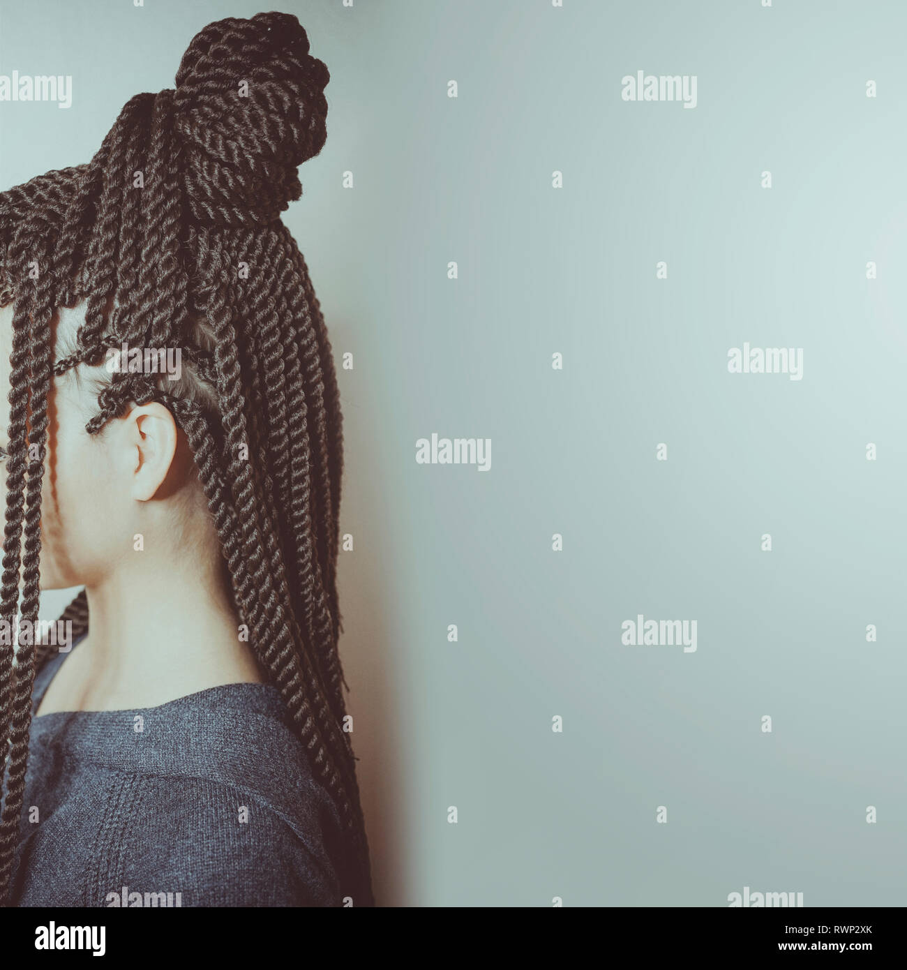 Sottili trecce vicino fino in stile africano sulla testa della ragazza, bangs, acconciatura capelli intrecciati Foto Stock