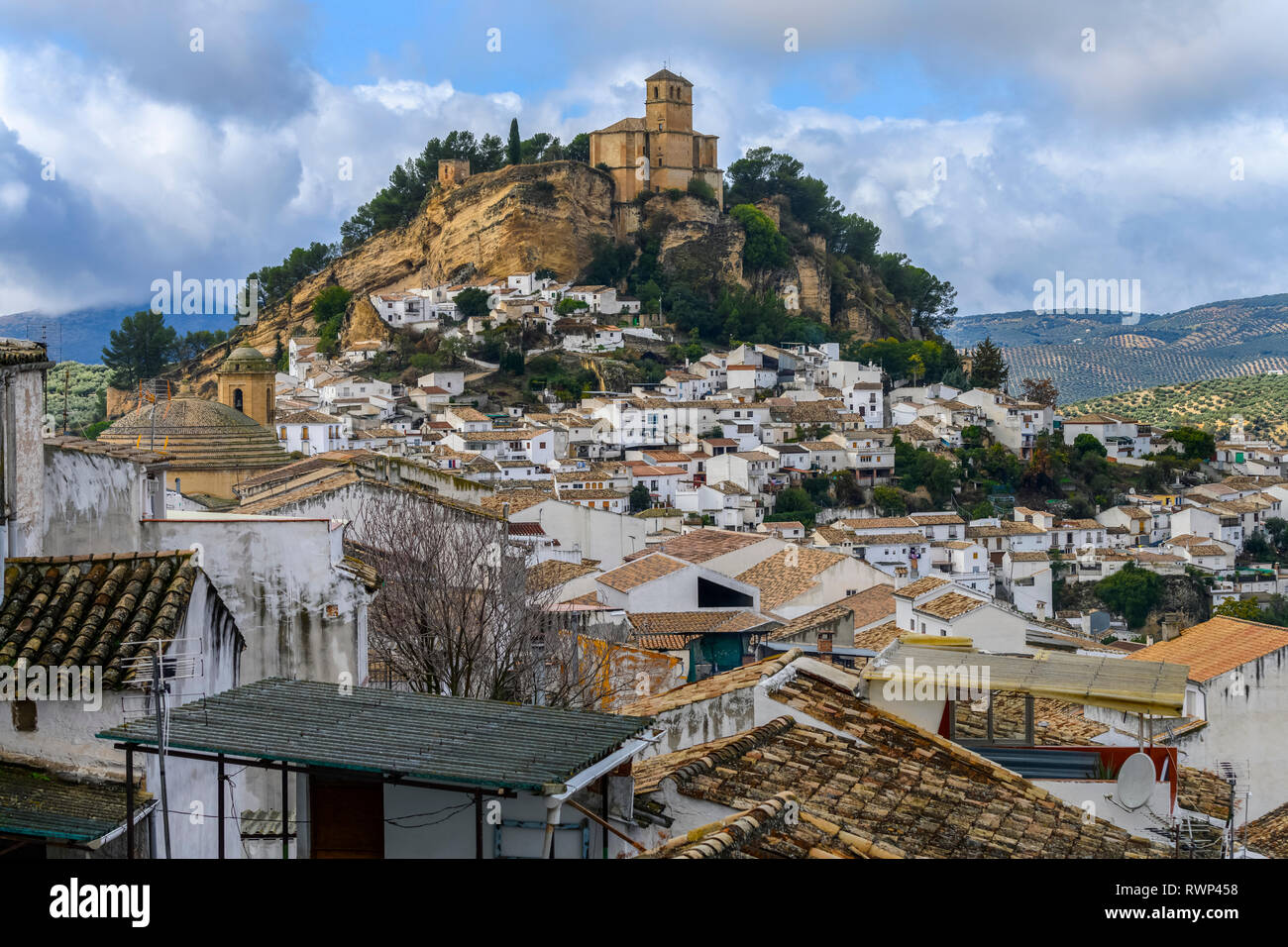 Le rovine di un castello moresco sulla cima di una collina con le case il riempimento della collina e gli uliveti delle colline; Montefrio, provincia di Granada, Spagna Foto Stock