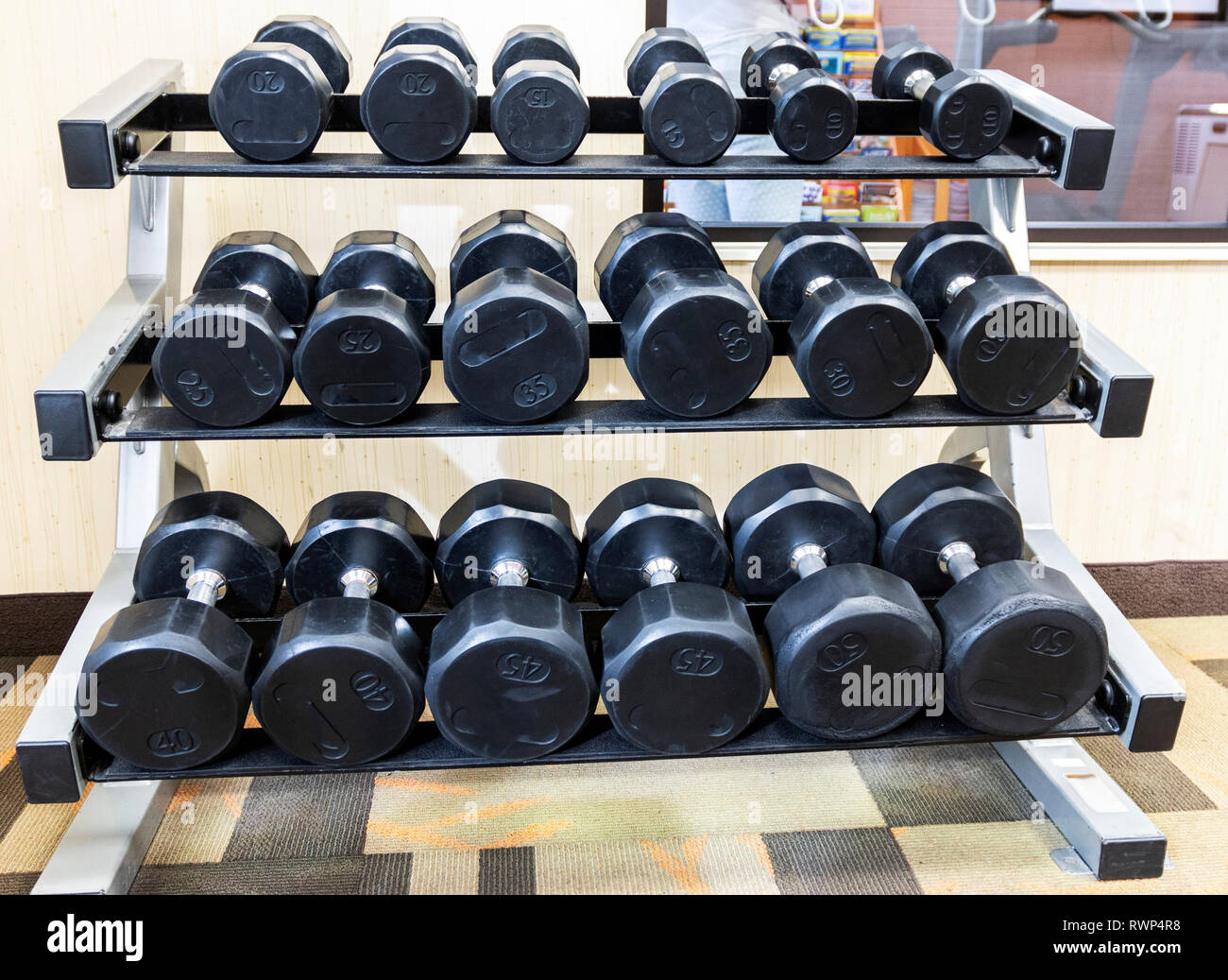 Molti manubri sono su un rack in una palestra. Foto Stock