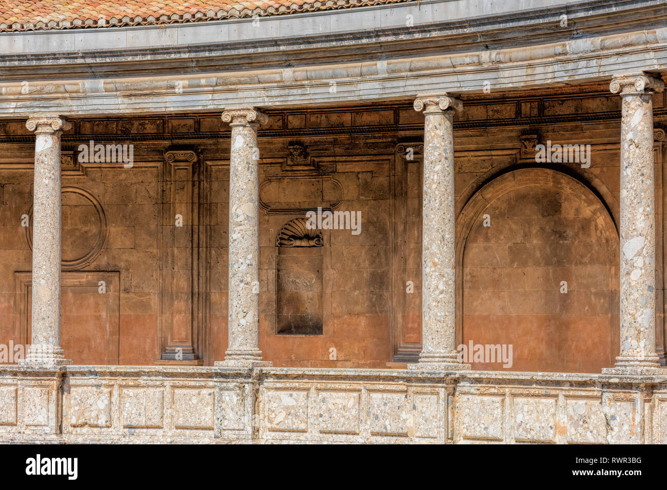 Stilizzata colonnato ionico il cui cornicione non ha alcuna decorazione sul piano superiore del palazzo di Carlo V all'interno della fortificazione Nasrid dell'Alhambra Foto Stock