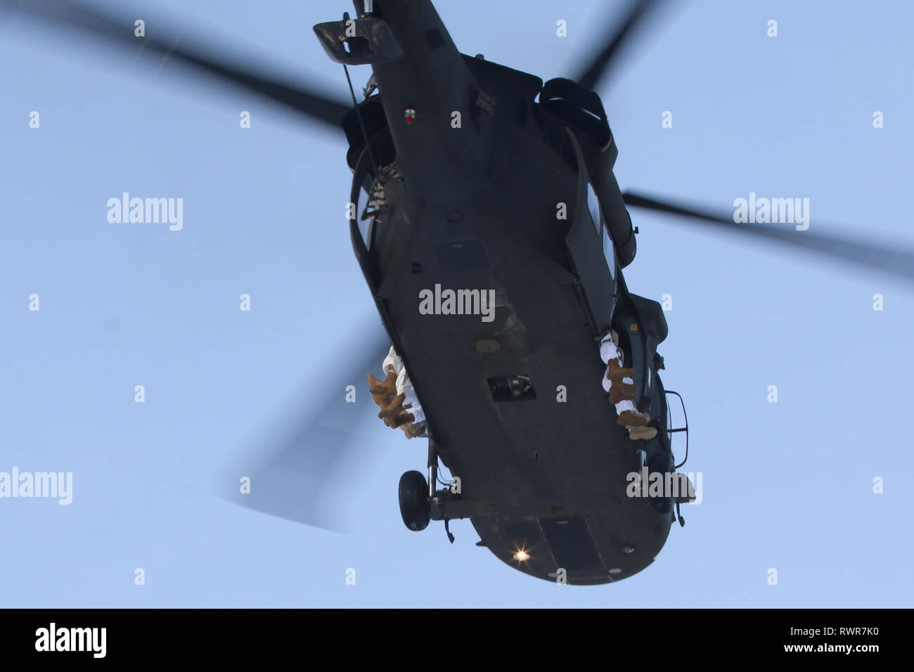 I paracadutisti con il quarto della brigata di fanteria combattere Team (airborne), XXV divisione di fanteria, U.S. Esercito di Alaska, sedersi sul lato di un UH-60 Blackhawk durante le operazioni di volo a base comune Elmendorf-Richardson, Alaska, 6 marzo 2019. Circa 300 i paracadutisti hanno preso spire di saltare su Alaska è coperta di neve nella zona di caduta da elicotteri. Quando si salta da un Blackhawk, paracadutisti sedersi sul lato dell'elicottero con le porte aperte. (U.S. Esercito foto di Sgt. Alex Skripnichuk) Foto Stock