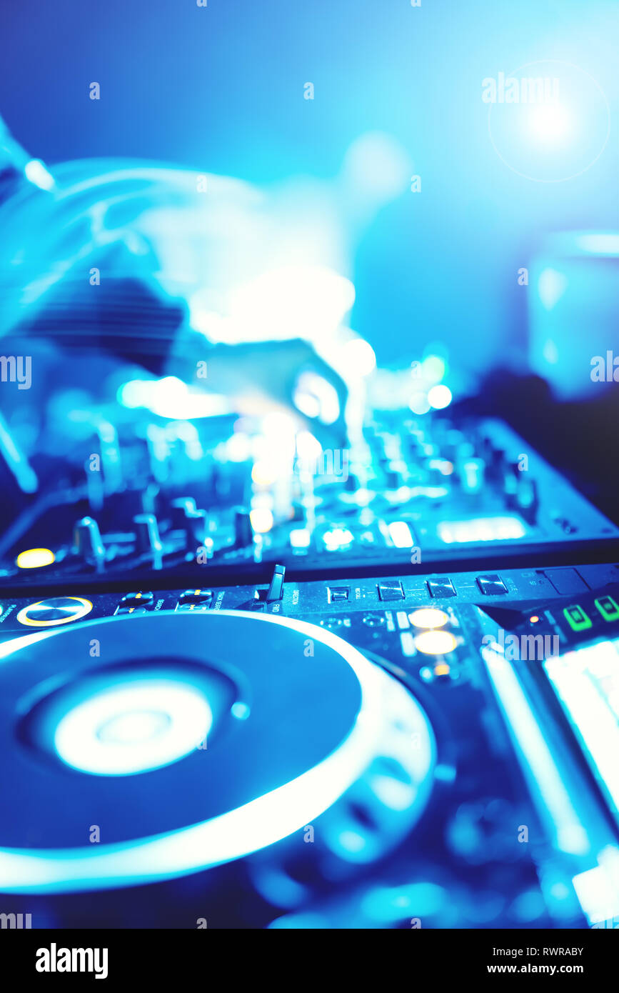 Morbida vista di man mano disc jockey di miscelazione e miscelazione di brani musicali sul suo ponte nelle tenebre di una parte o di un night club.Copia spazio per il testo. Foto Stock