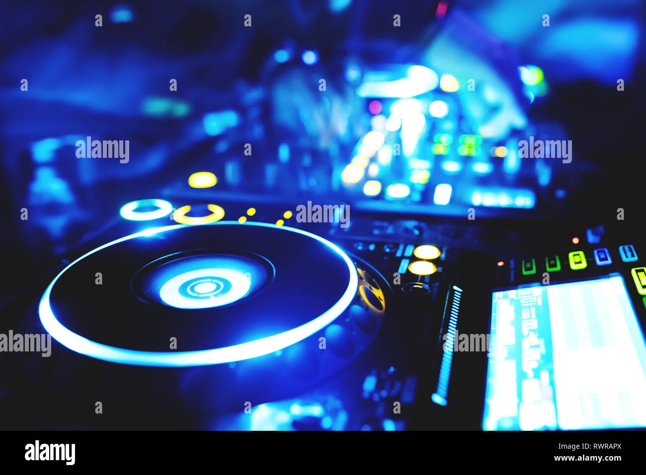 Morbida vista di man mano disc jockey di miscelazione e miscelazione di brani musicali sul suo ponte nelle tenebre di una parte o di un night club.Copia spazio per il testo. Foto Stock