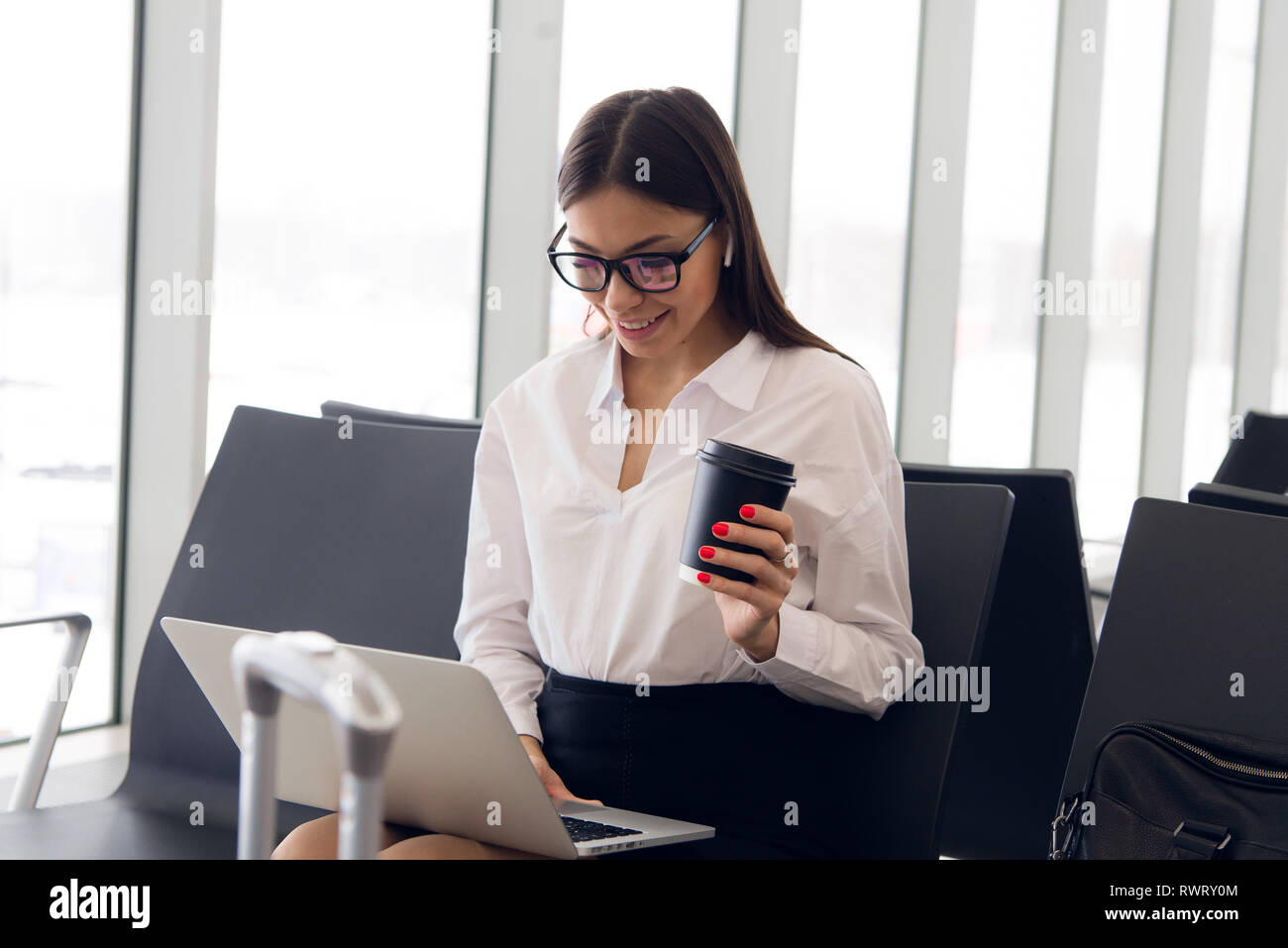 Breaktime business. Bella donna d'affari lavorando sul computer portatile mentre si è in attesa per il suo volo in un aeroporto. Foto Stock