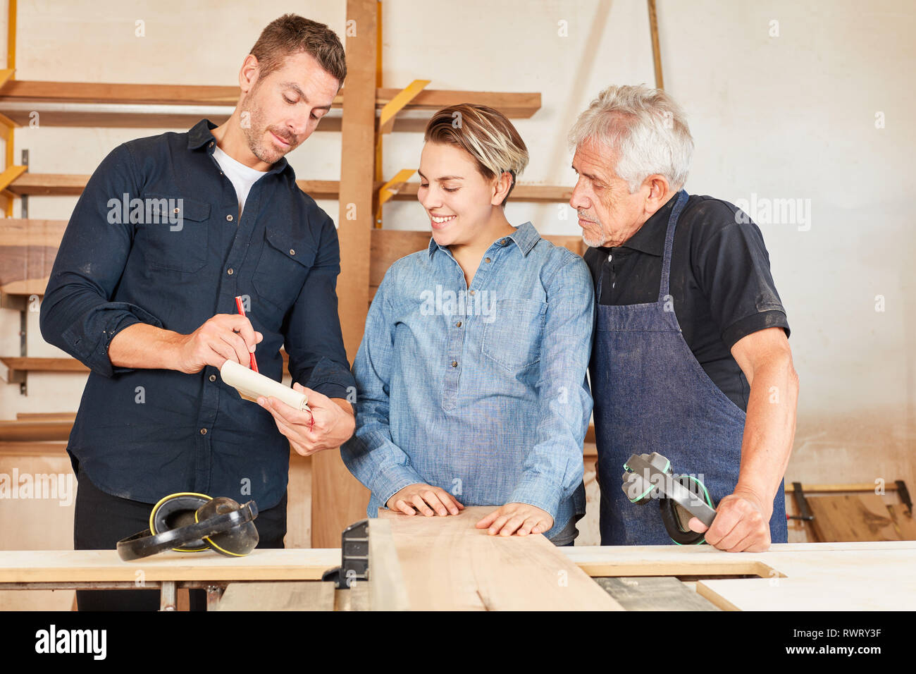 Gli artigiani di tirocinanti e maestri discutono un ordine in falegnameria Foto Stock