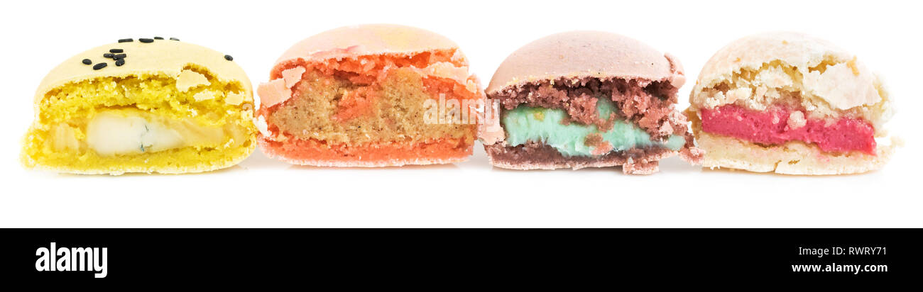 Diversi tipi di francese biscotti dolci, amaretti in fila tagliato a metà. Isolato su sfondo bianco. Vista laterale. Foto Stock
