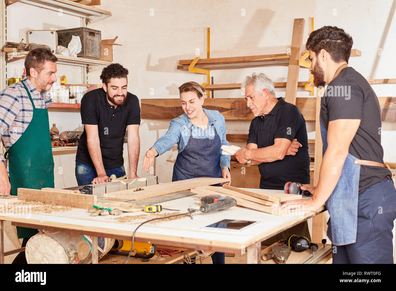 Giovane donna come un artigiano nell'artigiano esame per la ditta di falegnameria Foto Stock