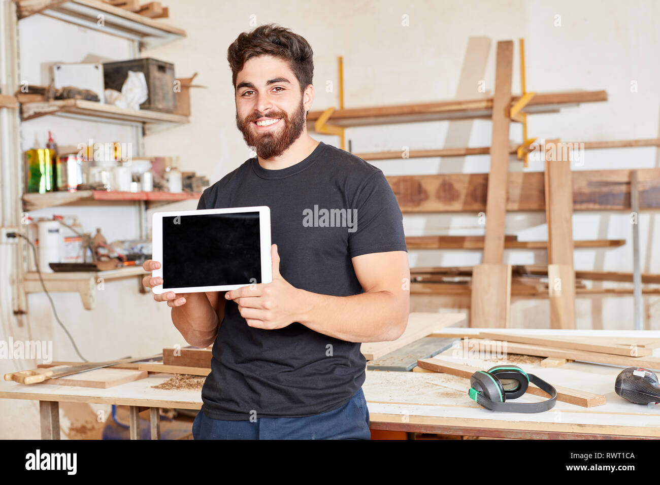 Giovane uomo come fondatore di un artigiano società presenta un computer tablet Foto Stock