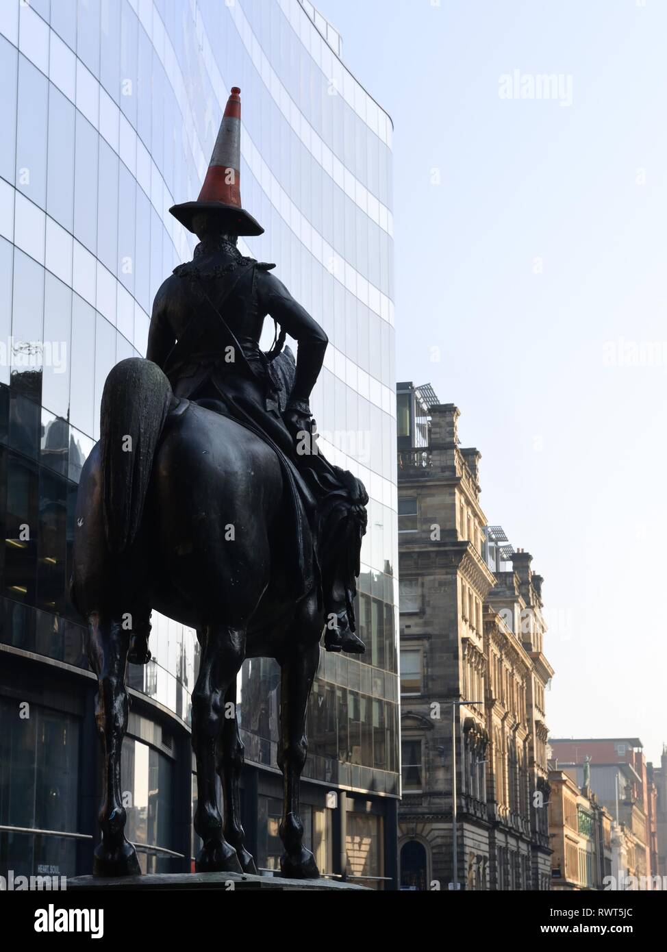 Il celebre Duca di Wellington statua del cavallo e cavaliere con il divertente aggiunta del cono di traffico sulla sua testa a Glasgow, Scotland, Regno Unito, Europa. Foto Stock