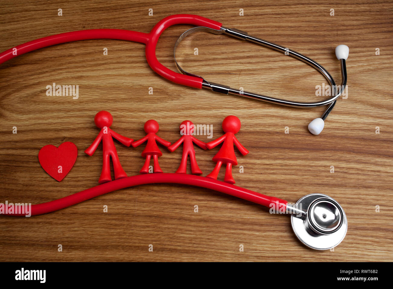 Lo stetoscopio e la famiglia la bambola con il cuore. Concetto di salute. Foto Stock