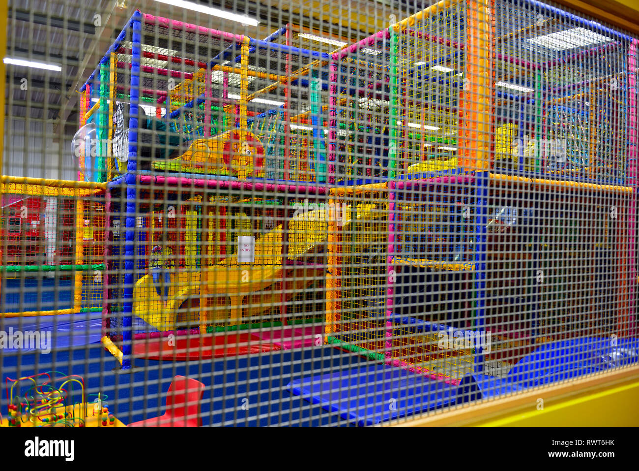 Abstract dei bambini del soft play area vista attraverso la griglia di protezione Foto Stock