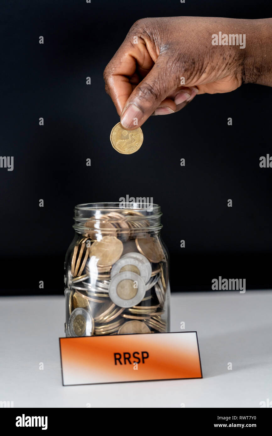 African American donna nigeriana la caduta delle monete nella giara di RRSP Foto Stock