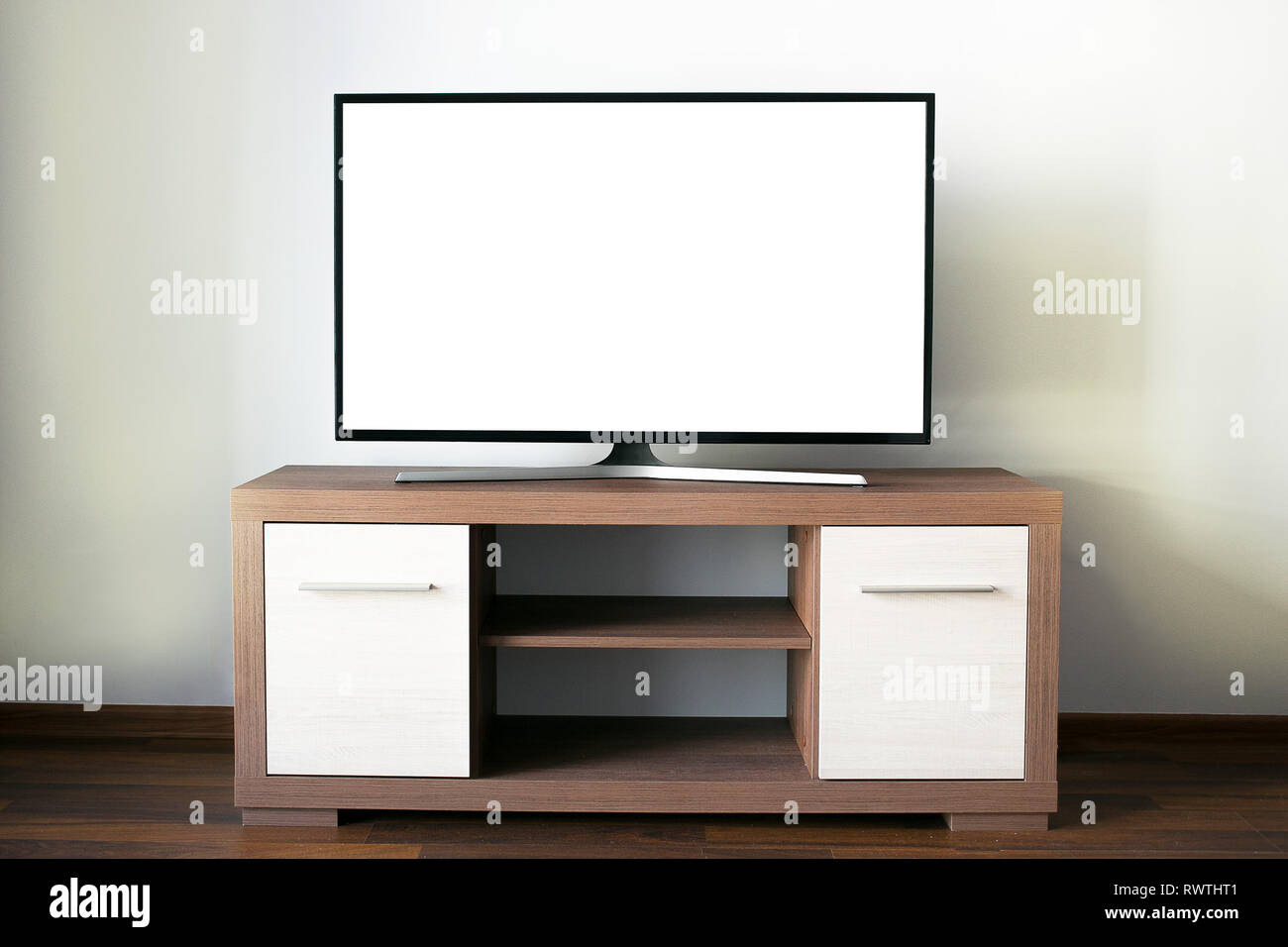 Appartamento grande televisione LCD con una schermata vuota su un di legno supporto per TV Foto Stock