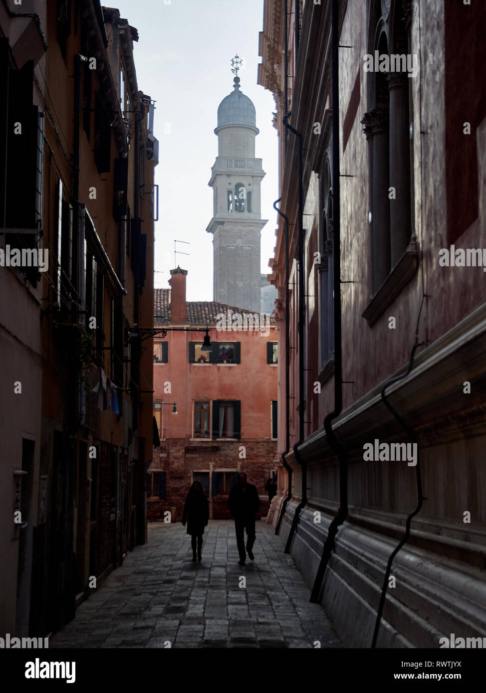 Venezia, Italia - Marzo 2, 2019 una coppia entra in un vicolo a Venezia durante un pomeriggio nuvoloso in inverno Foto Stock