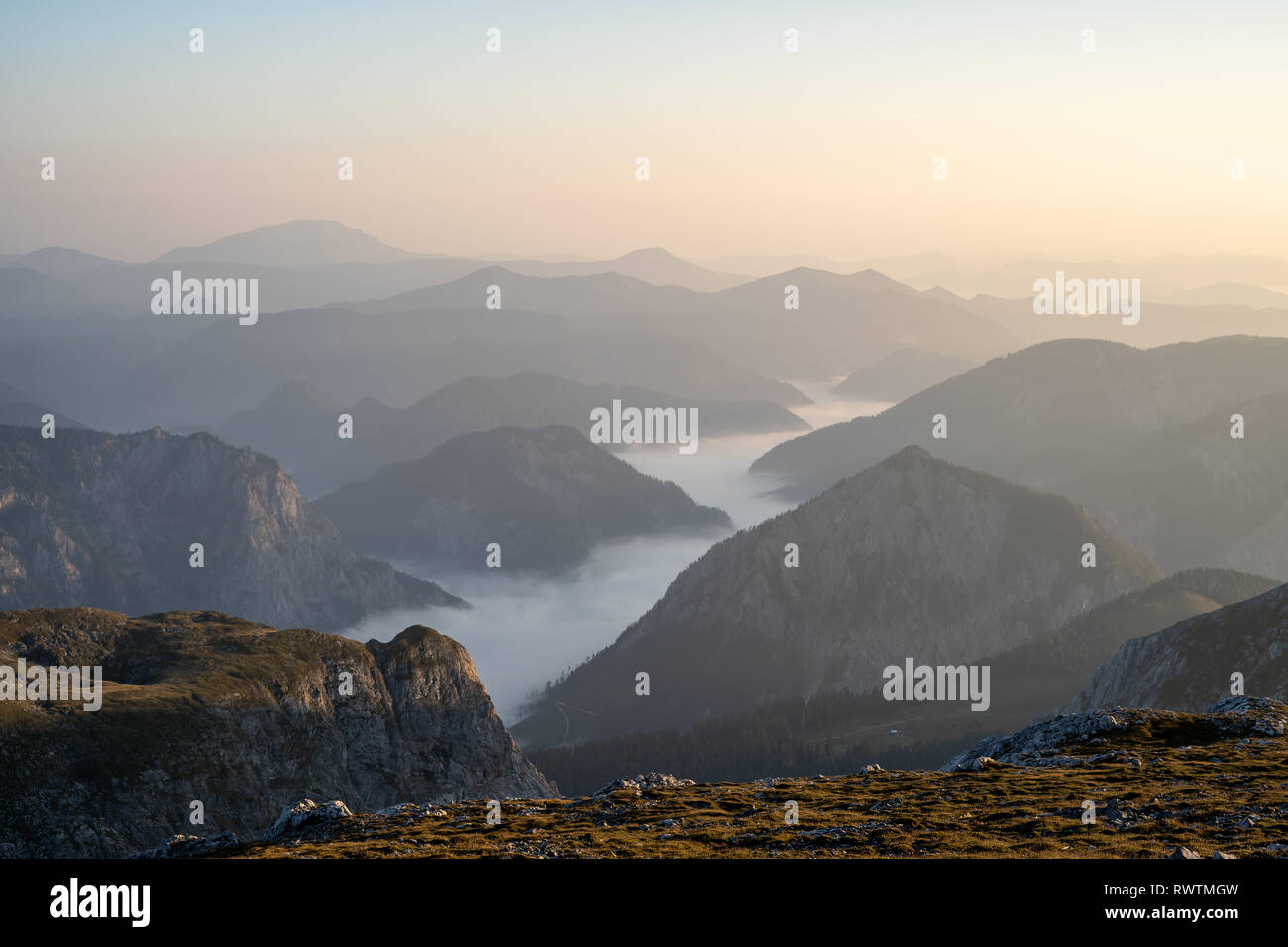 La valle di nebbia accanto all'Hochschwab moutain nelle prime ore del mattino, Austria Foto Stock