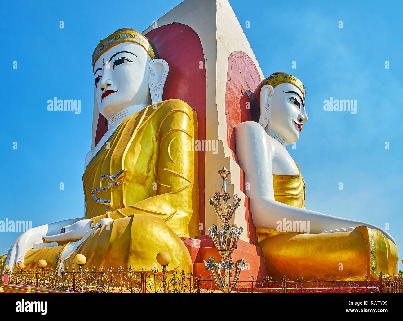 A piedi attorno a quattro statue di Budha signore in costumi dorati, situato in Kyaik Pun Pagoda, Bago, Myanmar. Foto Stock