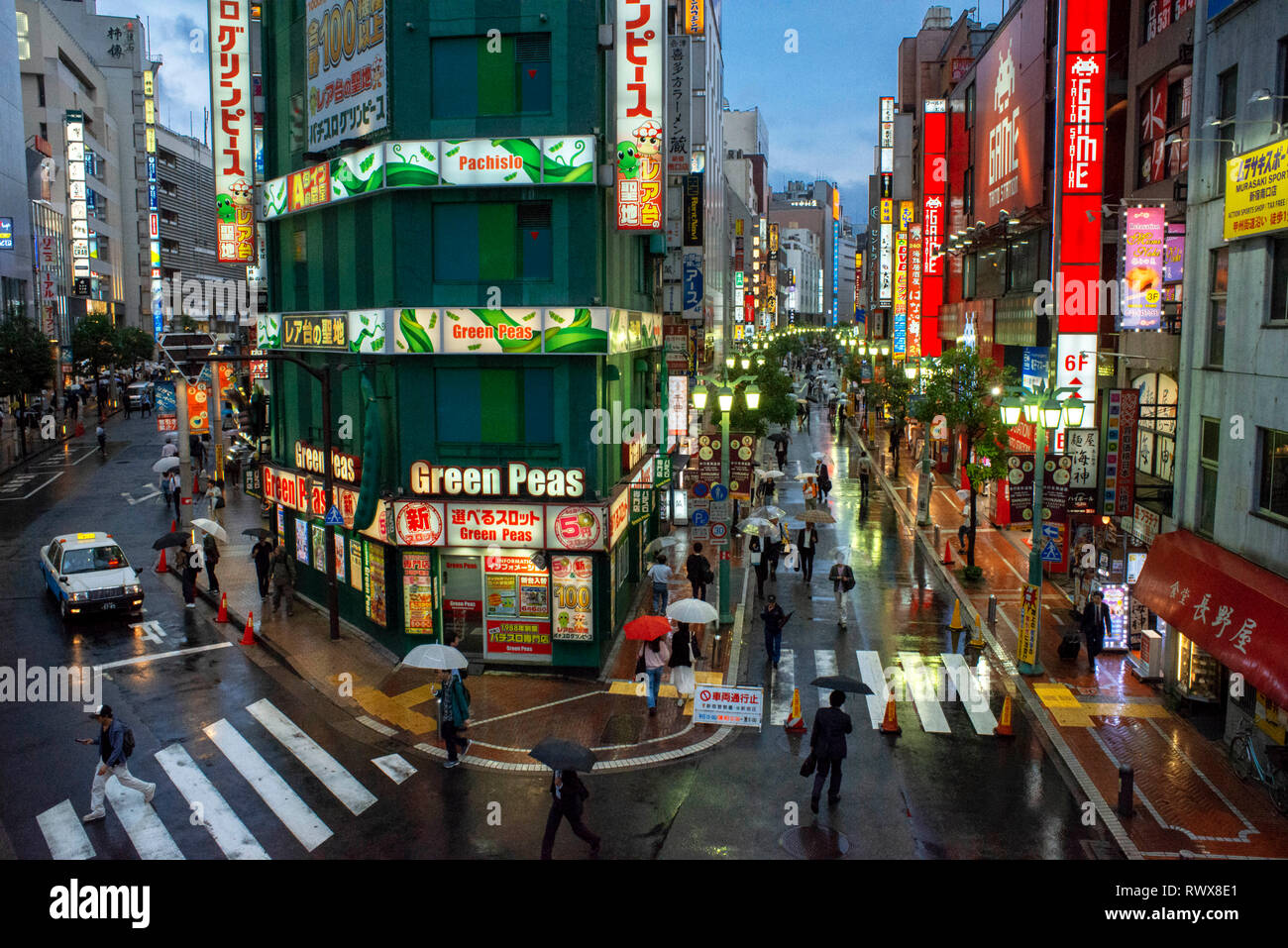 Piselli verdi Pachislo Pachinko e persone su una piazza alla stazione JR di Shinjuku uscita sud, Tokyo, Honshū, Giappone Foto Stock