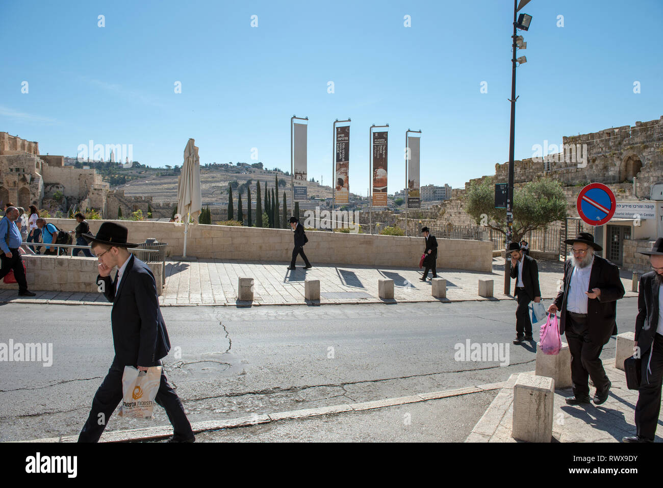 Gerusalemme, Israele - 16 Maggio 2018: Haredi ultra ebrei ortodossi a piedi su strees di Gerusalemme, Mount of Olives in background Foto Stock