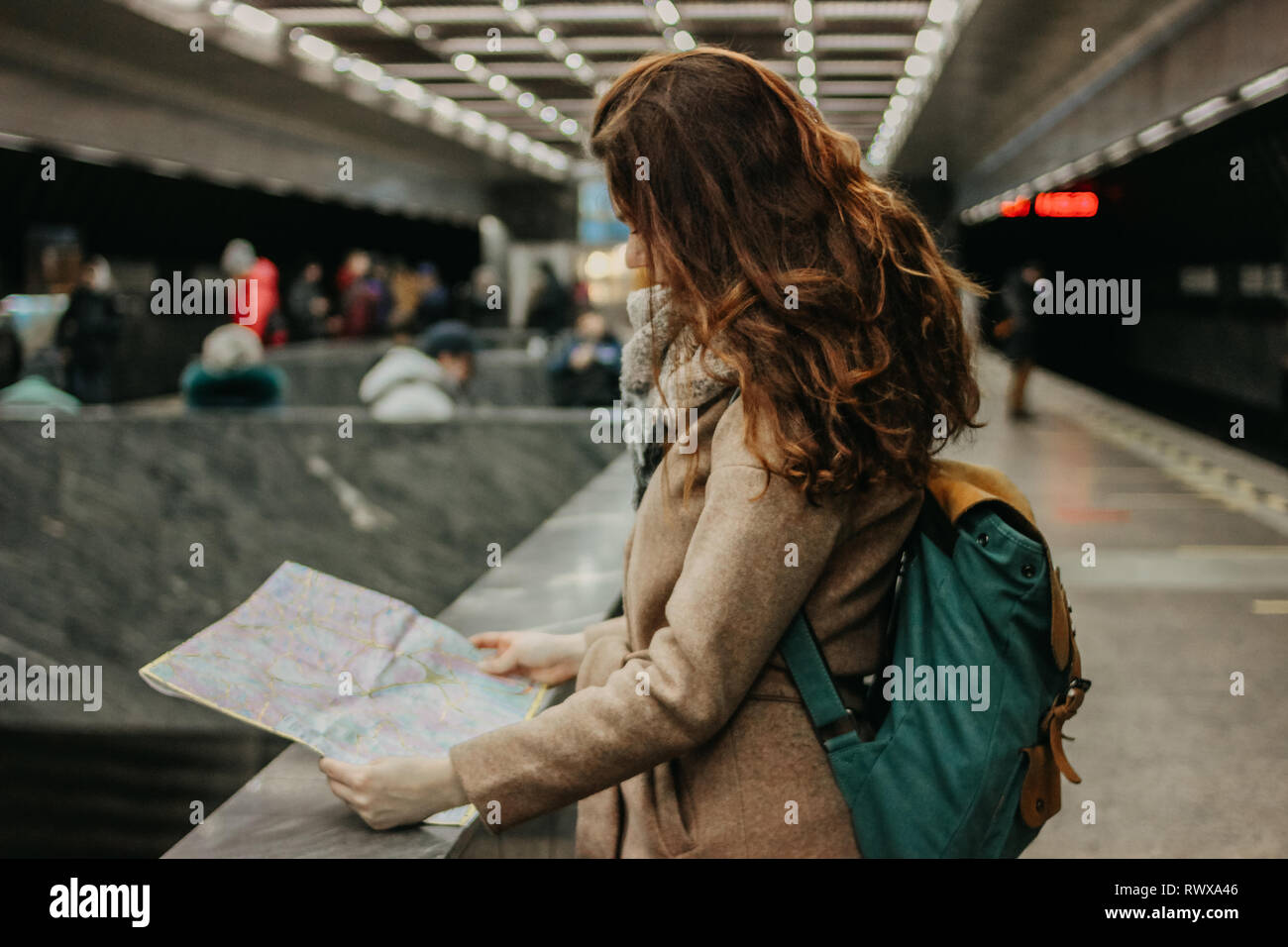 Giovane donna ricci testa rossa ragazza viaggiatori con zaino e mappa in metropolitana Foto Stock