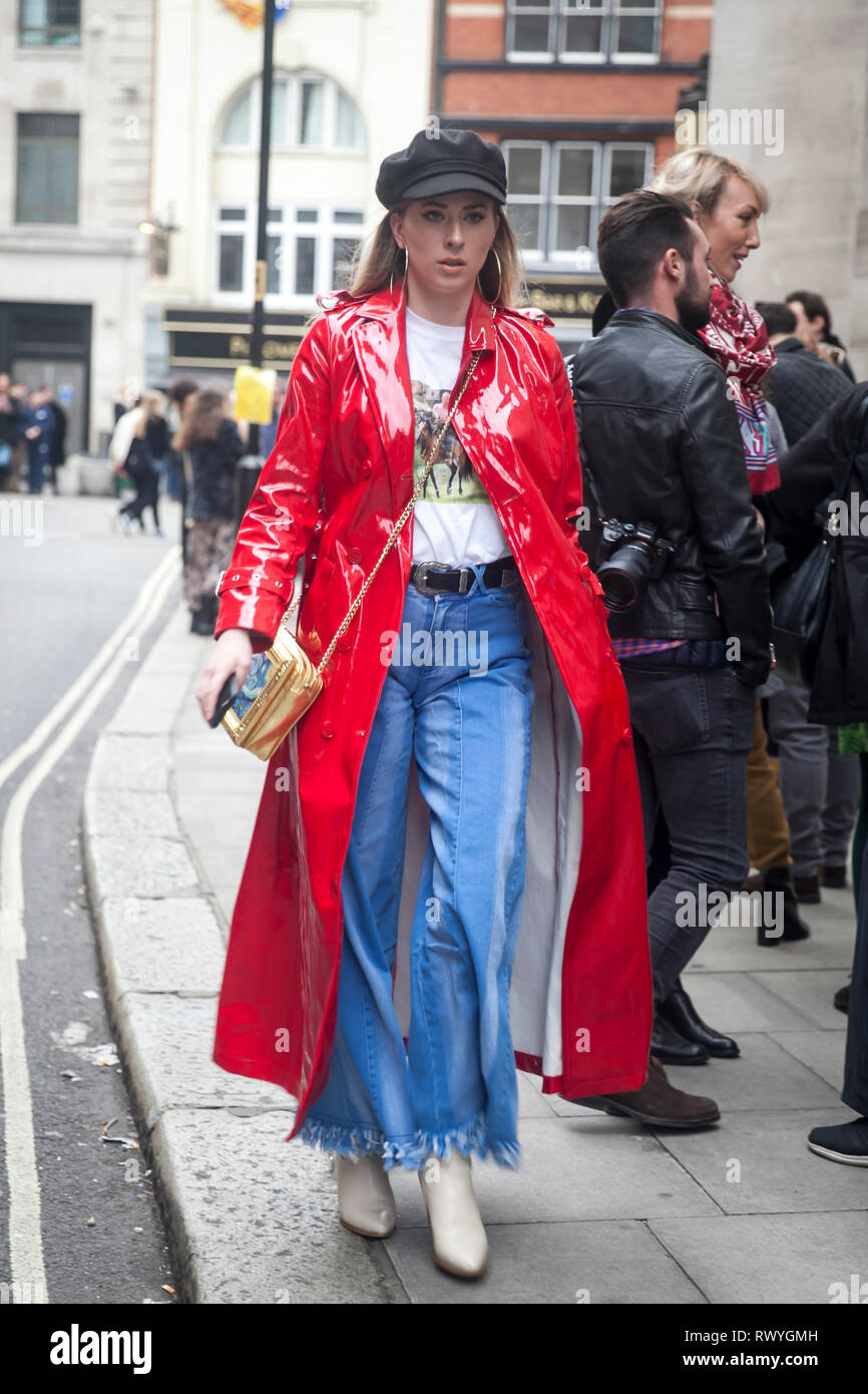 Londra - 15 febbraio 2019: Elegante partecipanti al di fuori di raccolta 180 del filamento per la London Fashion Week. ragazza bionda in un rosso Cappotto di pelle, svasato blu Foto Stock