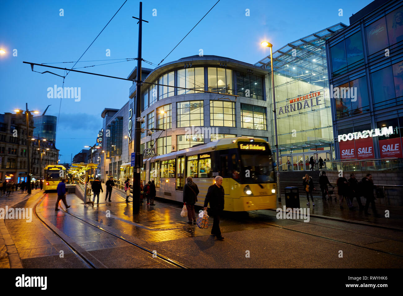 Bagnato e buio a Exchange Square e Manchester Arndale shopping centre mall entrata come un Metrolink tram parte Foto Stock