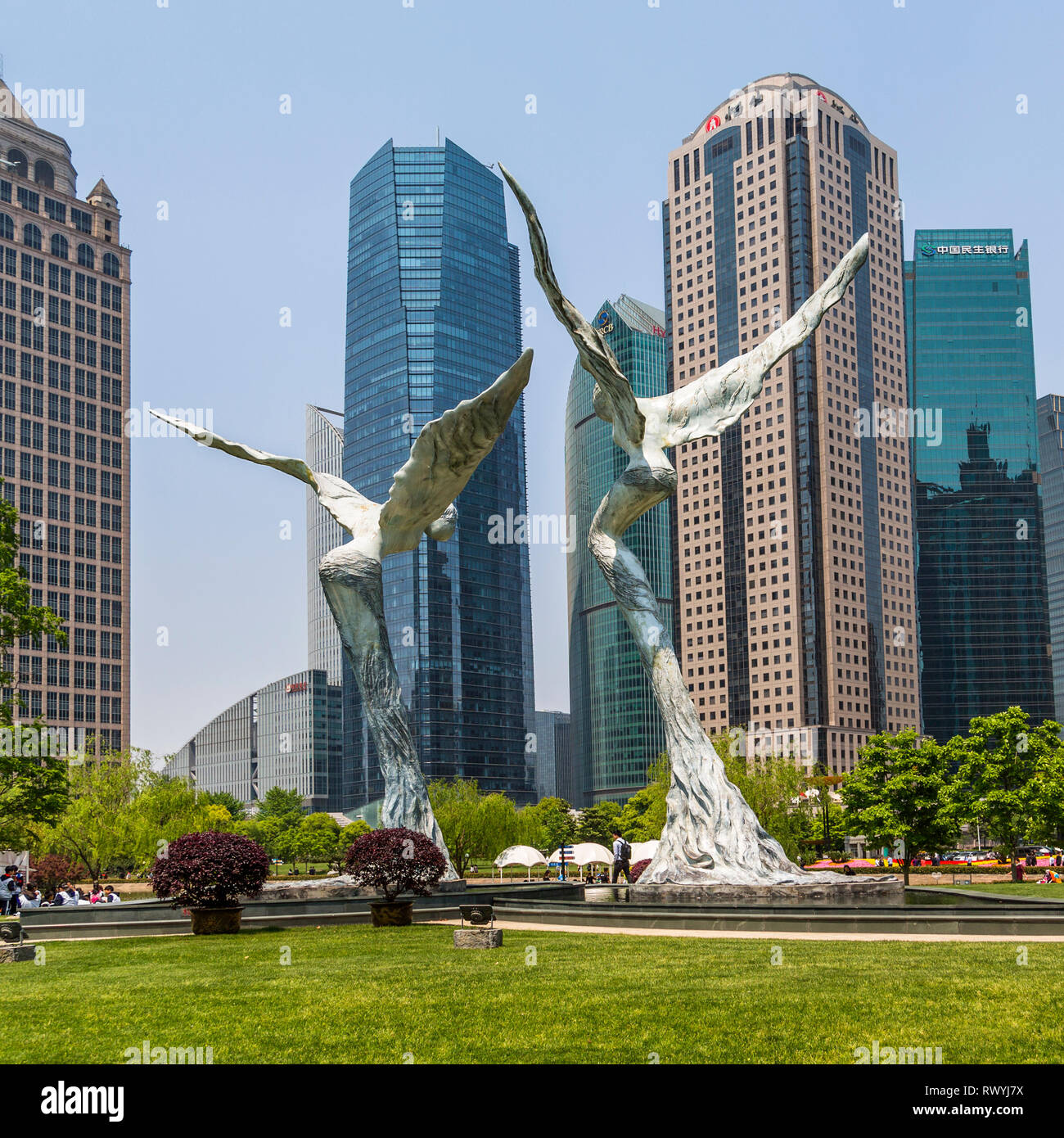 Angelo statue sollevarsi nella tranquillità del Parco di Lujiazui, circondata da possenti grattacieli di Pudong. Shanghai, Cina. Foto Stock