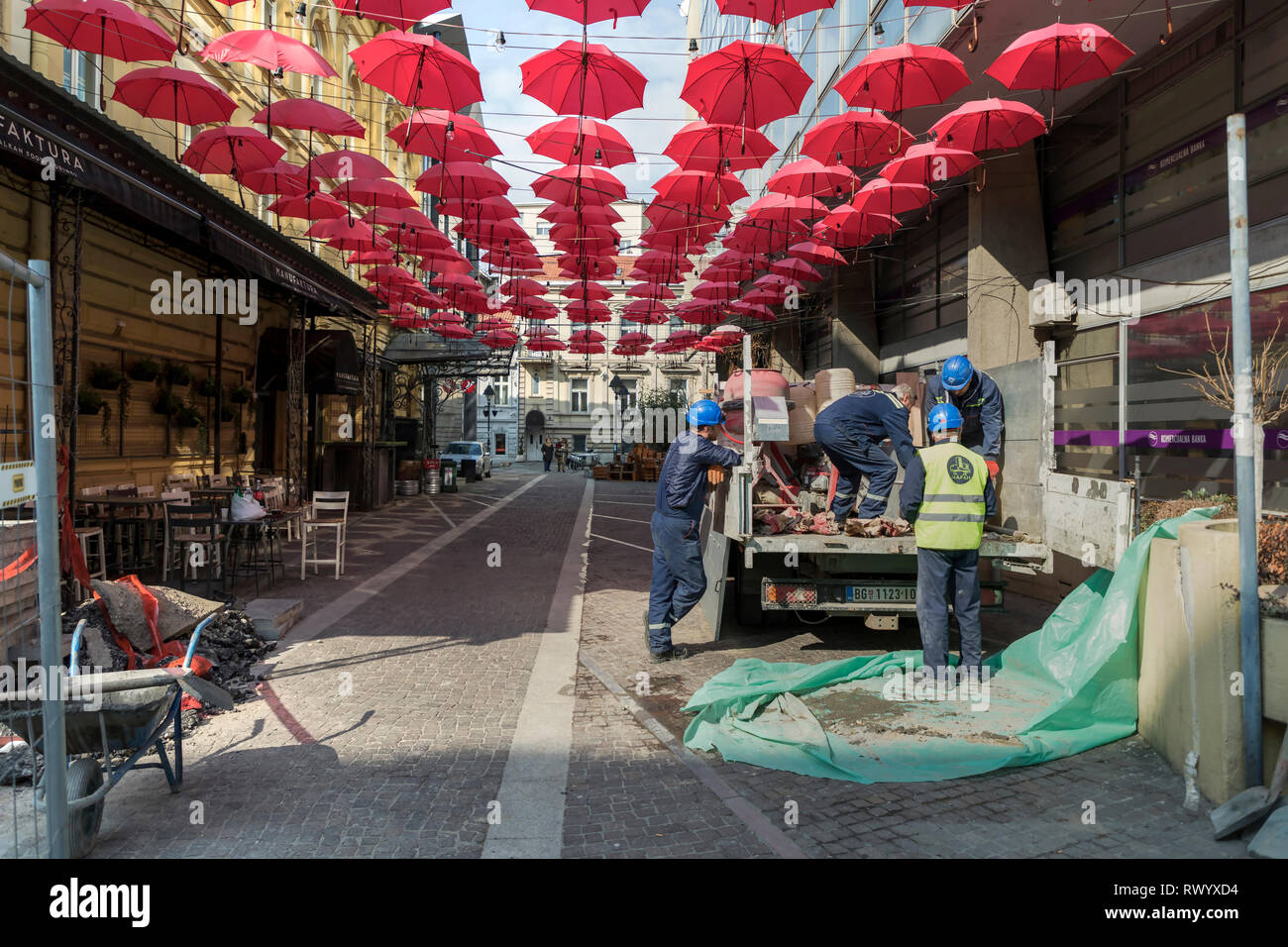 Belgrado, Serbia, Marzo 2019 - Costruzione dei lavoratori sul posto di lavoro in red ombrelloni sospesi al di sopra della cara Lazara strada pedonale in zona della città Foto Stock