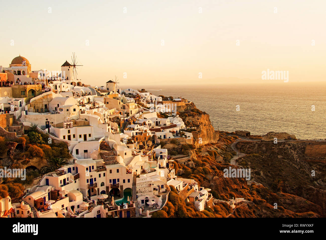 Splendido classico paesaggio con edifici bianchi vintage e mulini a vento in Oia sull isola di Santorini, Grecia al tramonto Foto Stock