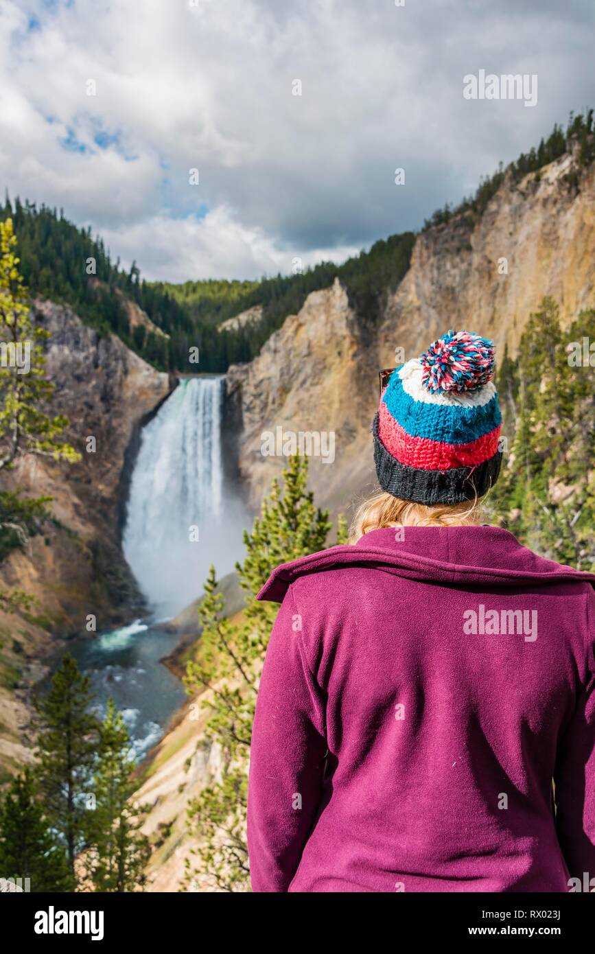 Giovane donna guardando una cascata, Red Rock Viewpoint, Cascate Inferiori, cascata in una gola, il Grand Canyon di Yellowstone River Foto Stock