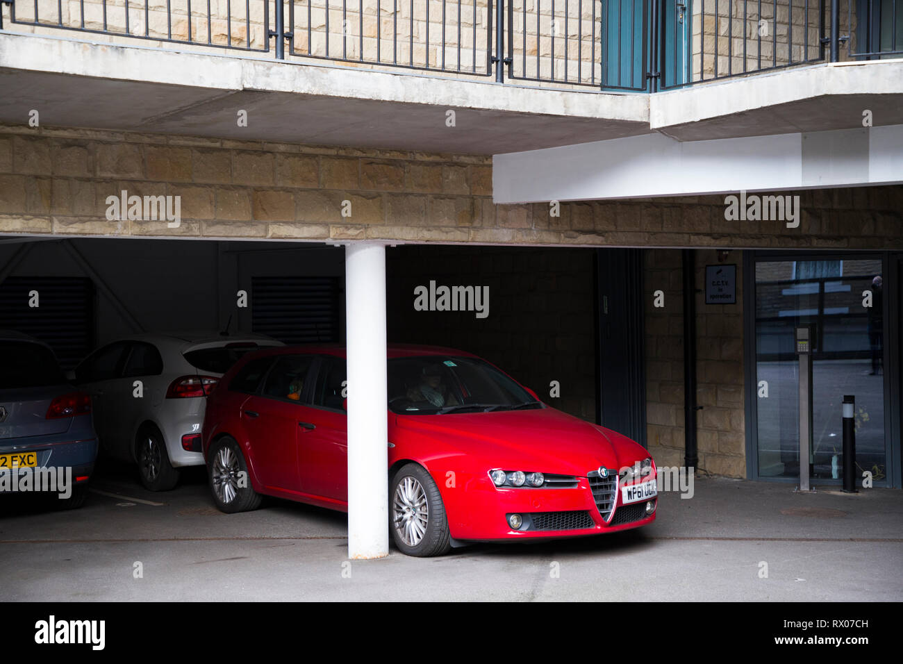 Una macchina parcheggiata in Halifax con proprio parcheggio / Justpark / justpark.com online parcheggio auto privato. Regno Unito. Lo spazio si trova al piano terra in un blocco di appartamenti. Foto Stock