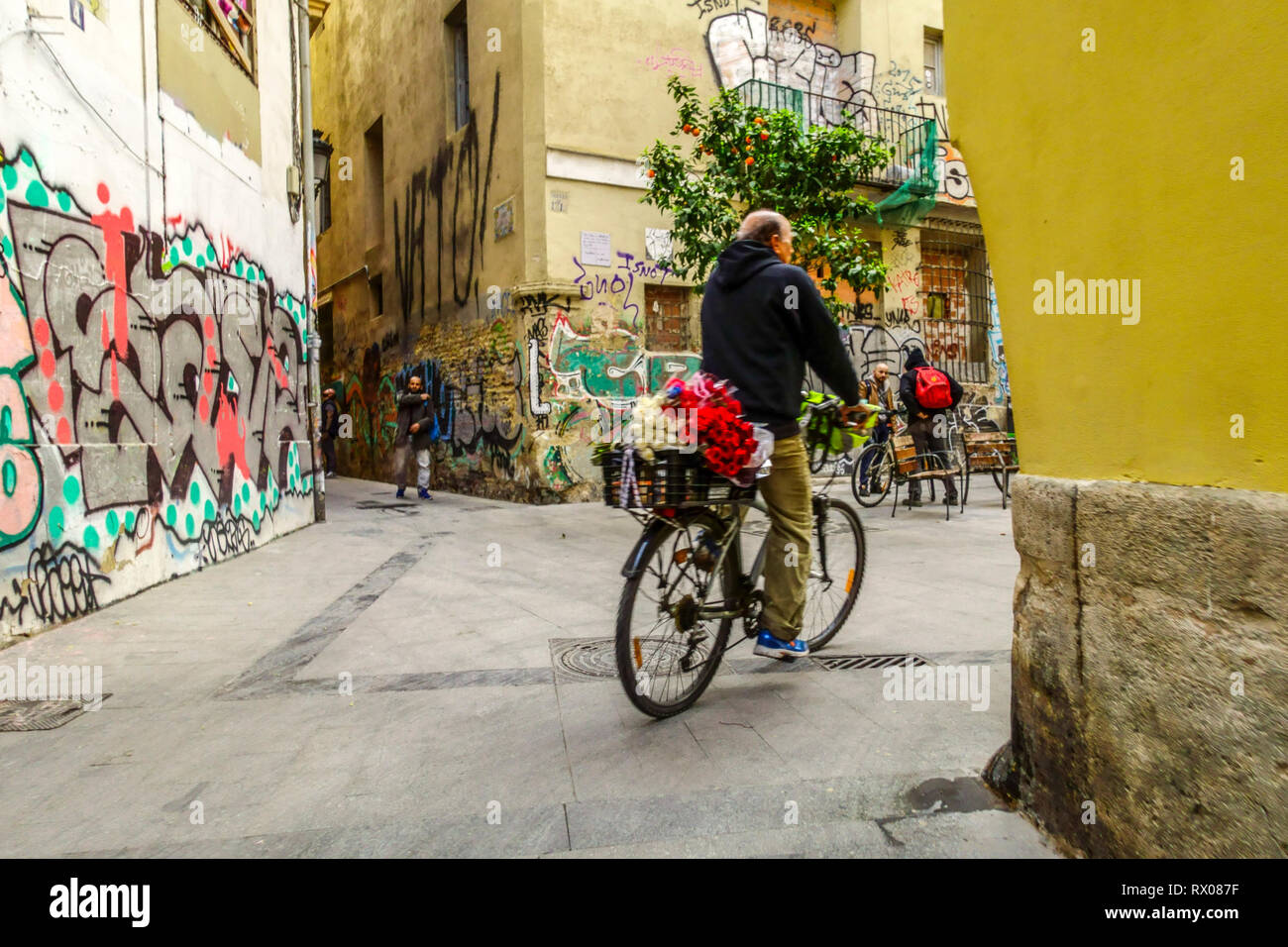 L'uomo su di una bicicletta è di offrire fiori, El Carmen district, Valencia Old Town, Spagna Foto Stock