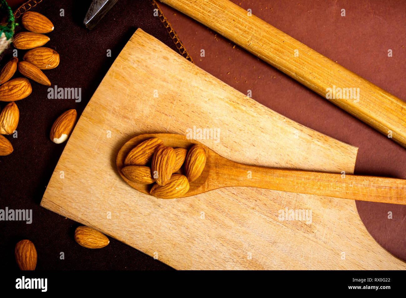 Mazzetto di mandorle e un martello su un tavolo Foto Stock