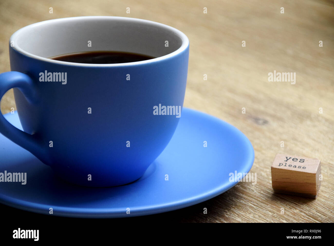 Blue tazza di caffè accanto a un cartello che diceva sì si prega di Foto Stock