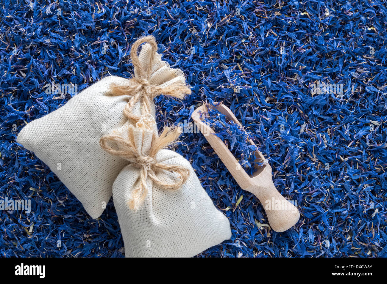 Sfondo di asciugare il blu fiordaliso, due sacchetti di bustina e scoop di legno. Vista dall'alto. Foto Stock