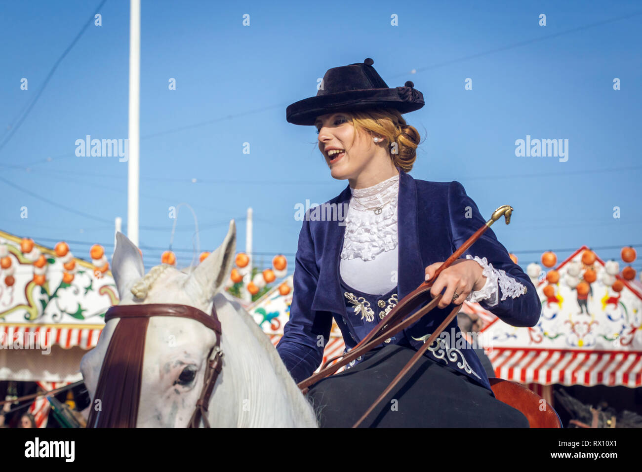 Giovane e bella donna attraente cavalcare cavalli andalusi (puro Cavallo Spagnolo) e la celebrazione di Siviglia fiera di aprile Foto Stock