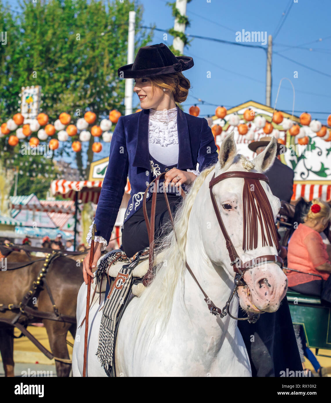 Giovane e bella donna attraente cavalcare cavalli andalusi (puro Cavallo Spagnolo) e la celebrazione di Siviglia fiera di aprile Foto Stock