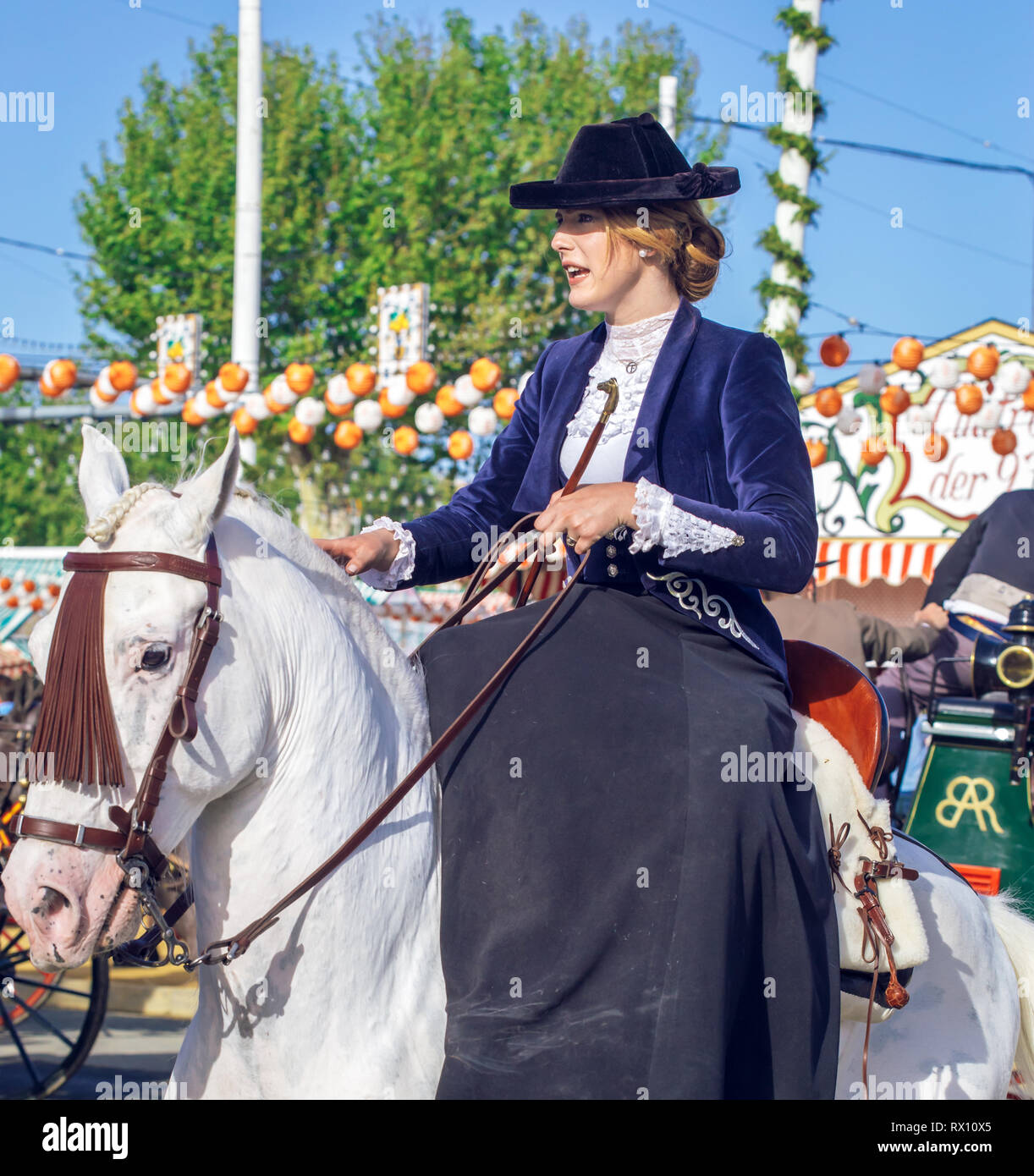 Giovane e bella donna attraente cavalcare cavalli andalusi (puro Cavallo Spagnolo) e la celebrazione di Siviglia fiera di aprile Foto Stock