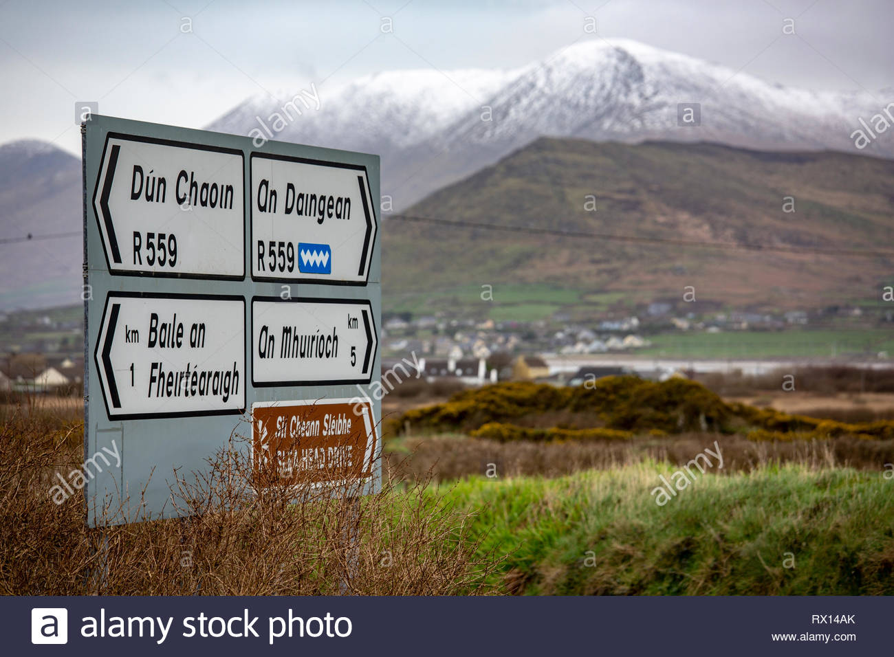 Neve sulle montagne in di lingua irlandese area del West Kerry come un segno mostra il modo per i villaggi della zona. Foto Stock