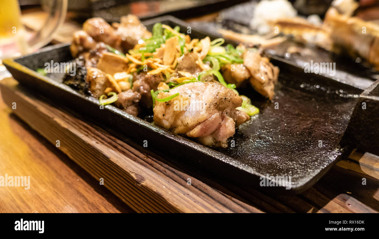 Pollo serviti durante la cottura sul piatto metallico in giapponese izakaya ristorante di stile Foto Stock