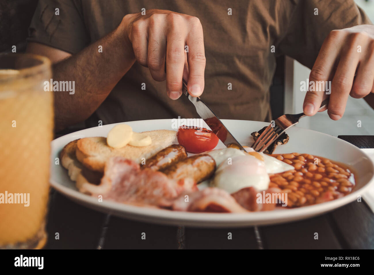 Uomo Di Mangiare Una Prima Colazione Inglese Con Succo Di Arancia Su Una Tavola Nera Foto Stock Alamy