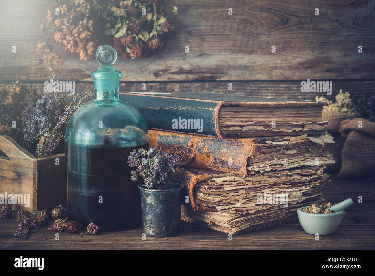 Tintura di bottiglie, assortimento di secca erbe sane, vecchi libri, Malta, farmaci curativi. La medicina di erbe. In stile retrò. Foto Stock