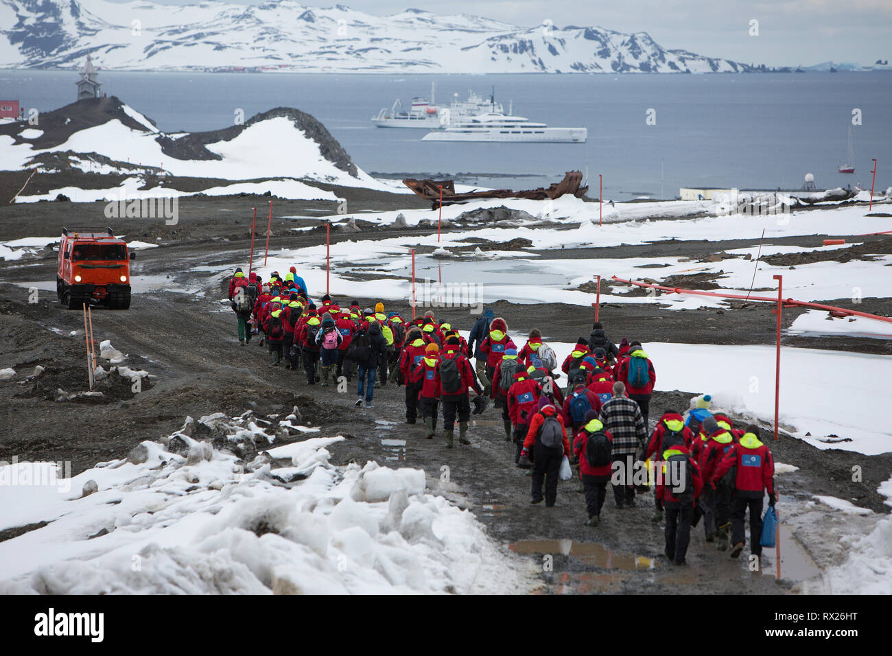 Passeggeri a piedi lungo una strada fangosa per attesa di nave da crociera nave fuori del re George isola, a sud le isole Shetland, Penisola Antartica, Antartide Foto Stock