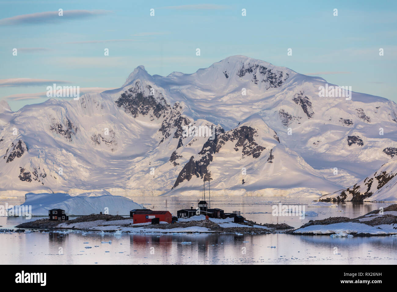 Montagne ghiacciate offrono lo sfondo per una base cilena in Paradise Harbour, Penisola Antartica, Antartide Foto Stock