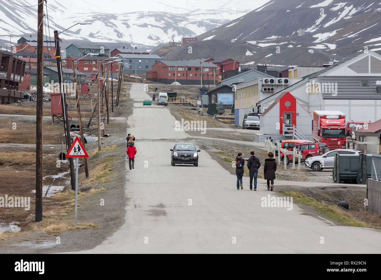 I visitatori a piedi giù per una strada a Longyearbyen, una piccola comunità Norvegese situato a 78.22N 15.65E mondi più settentrionali della Comunità di qualsiasi tipo con maggiore di 1000 residenti permanenti. Isola Spitsbergen, Svalbard, Norvegia. Foto Stock
