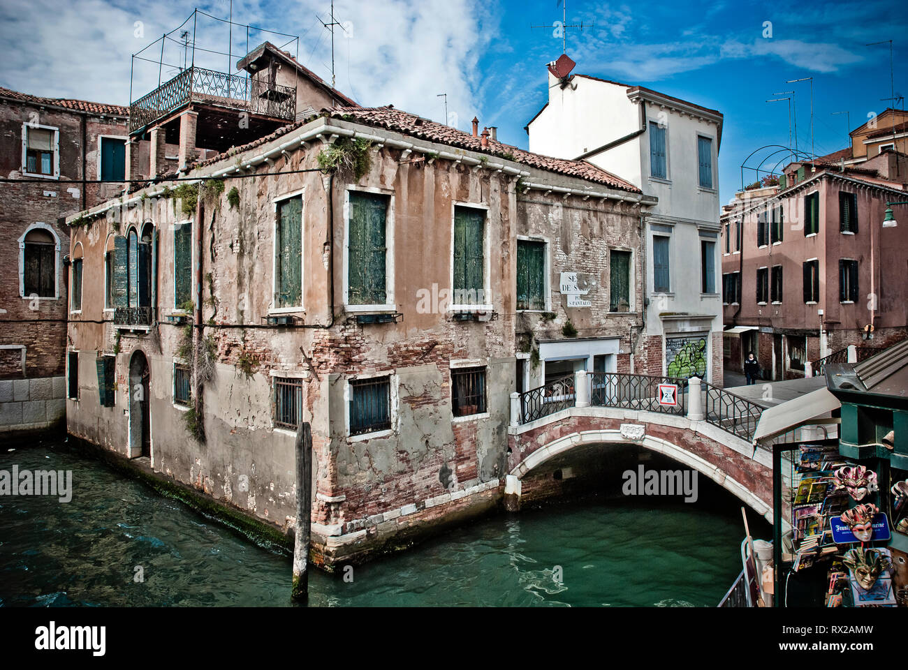 Ponte pedonale e vecchio edificio lungo un canale di Venezia, Italia Foto Stock