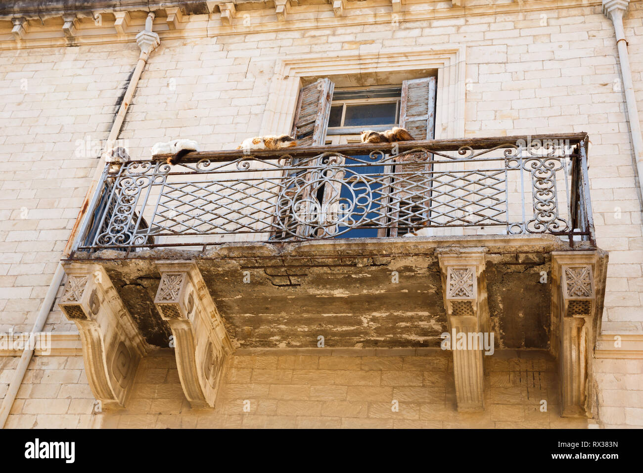 Vecchio edificio con bellissimo balcone e gatti in Limassol, Cipro. Foto Stock